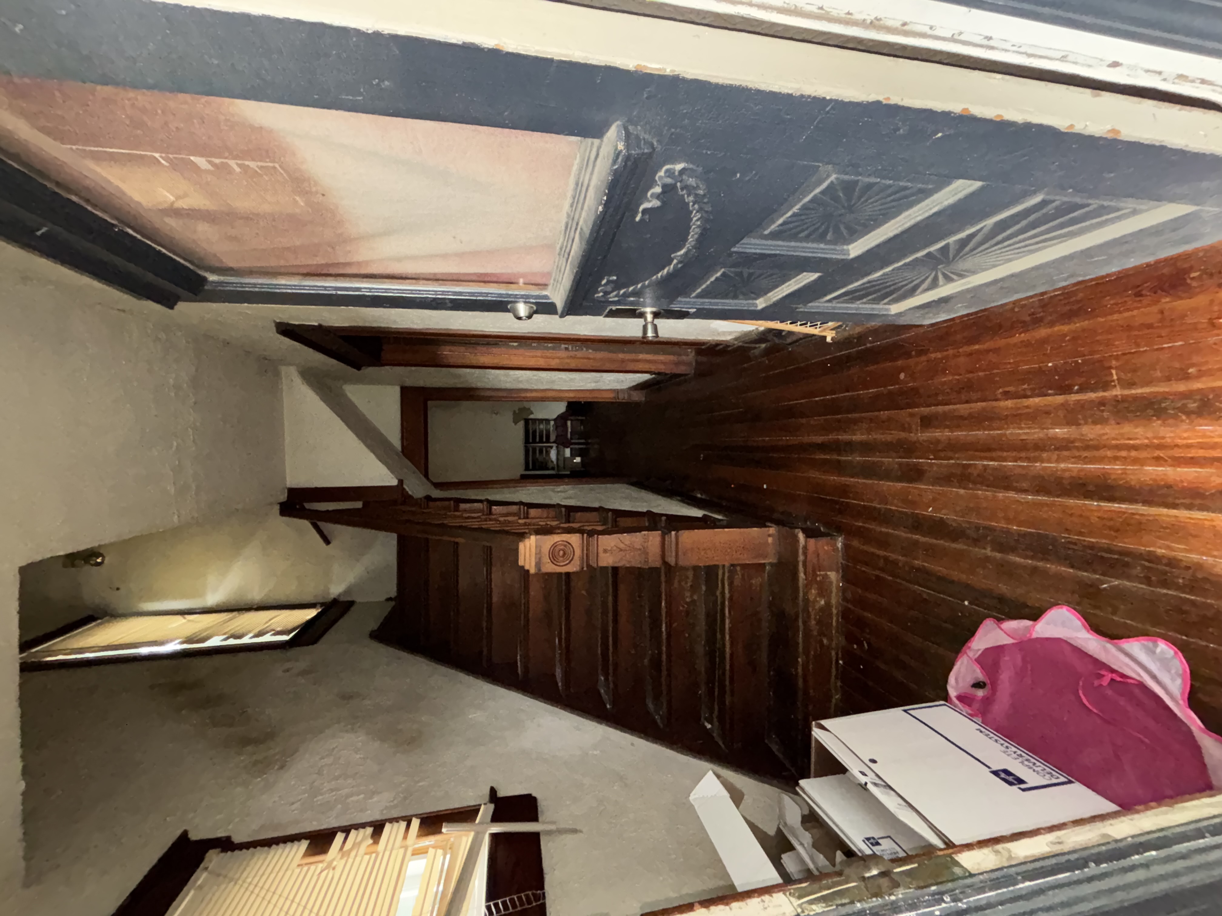 Staircase before - dark wood, damaged entry, debris